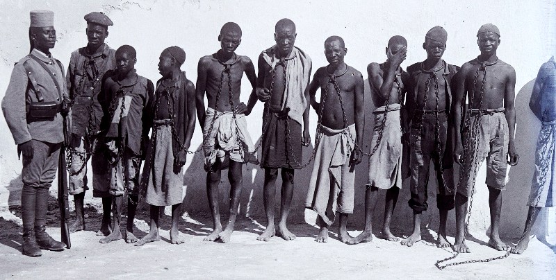 Chained prisoners in German East Africa guarded by an Askari soldier